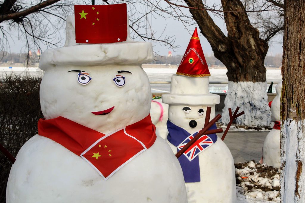 Two snowmen wearing flags.