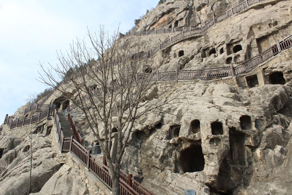 Many caves in the hillside with many staircases leading up and connecting to each other.