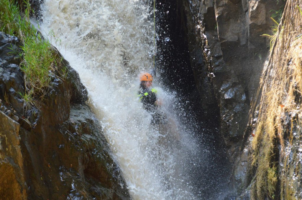 Me abseiling down into a powerful waterfall in Da Lat
