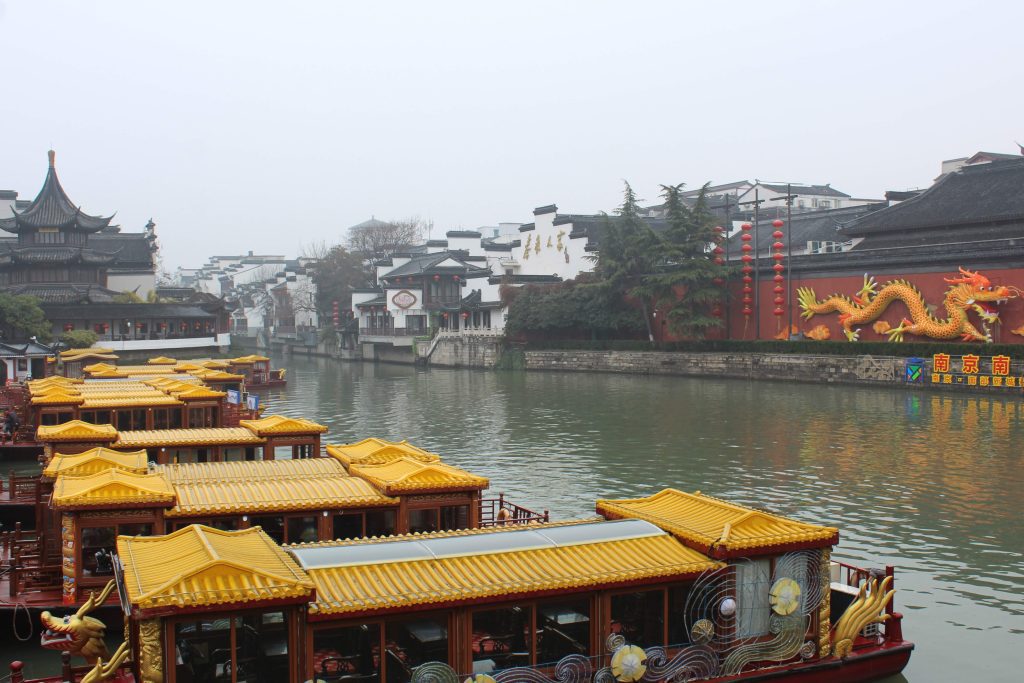 Photo of Qinhuai river with yellow boats on the left bank.