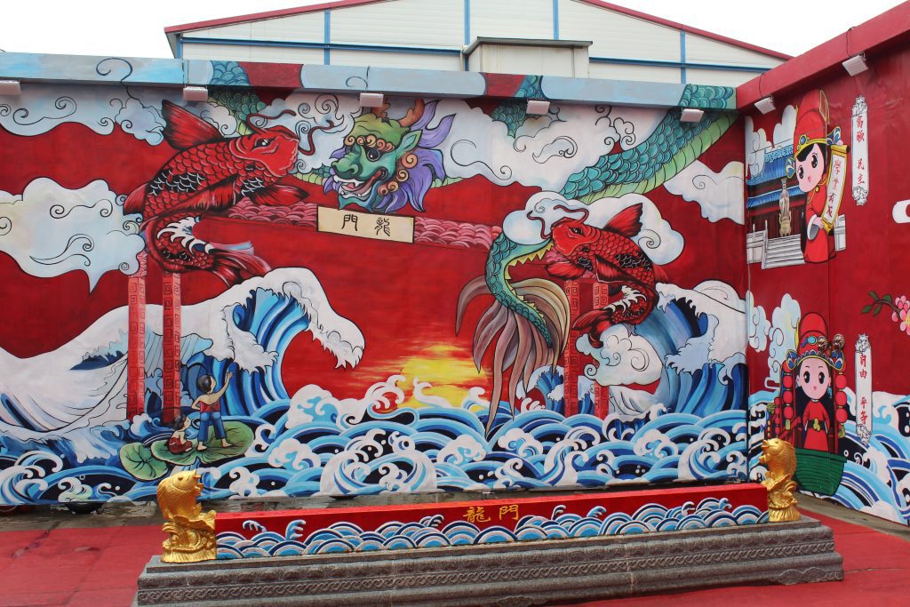 Photo of brightly painted wall with images of waves and fish.