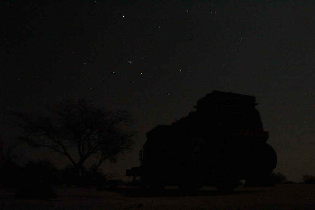 Photo of stars with the silhouette of a tree and our bus.