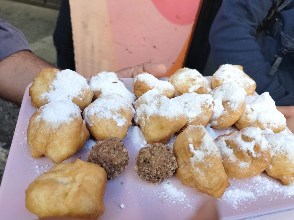 Photo of dough balls covering in icing sugar.