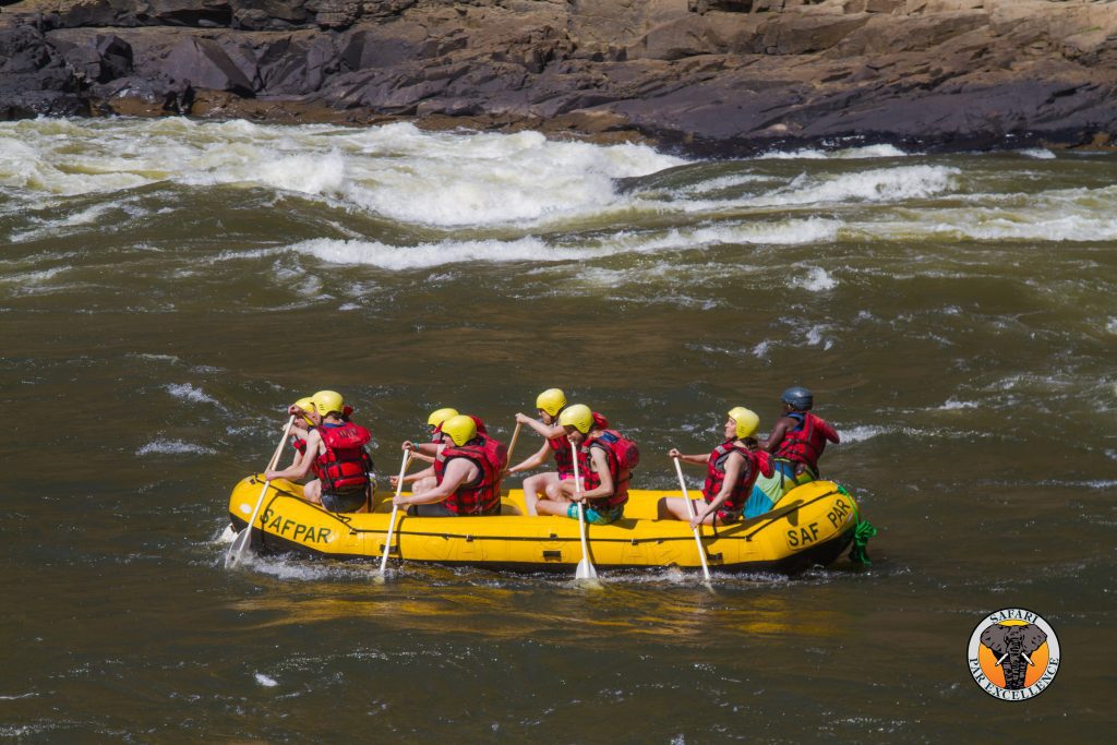 Photo of white water raft with rapids in the background.
