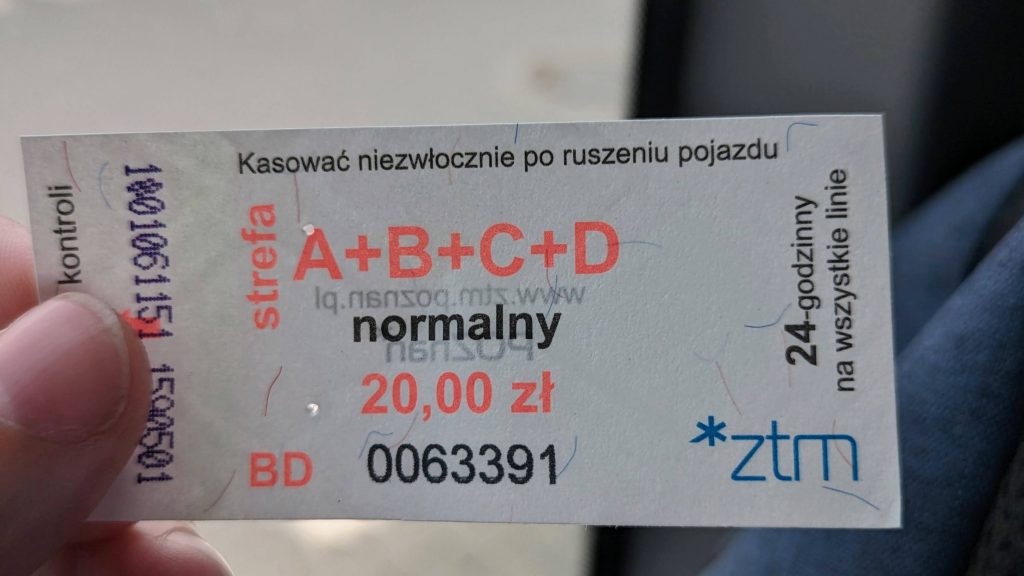 Photo of a bus ticket that says A+B+C+D and the word "normalny". The ticket says it costs 20 zloty and on the side it says 24-godzinny. On the left are some printed numbers that show the time and date it was validated for the first time. The ticket can last for two days in Poznan if validated at the weekend.