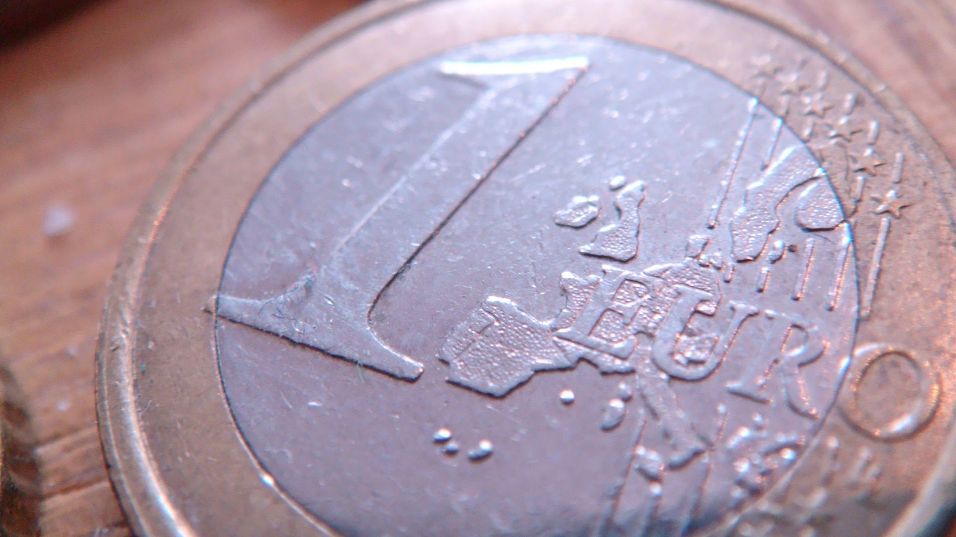 Photo of a 1 euro coin. It is the side that says 1 Euro and has the map of the EU on it.